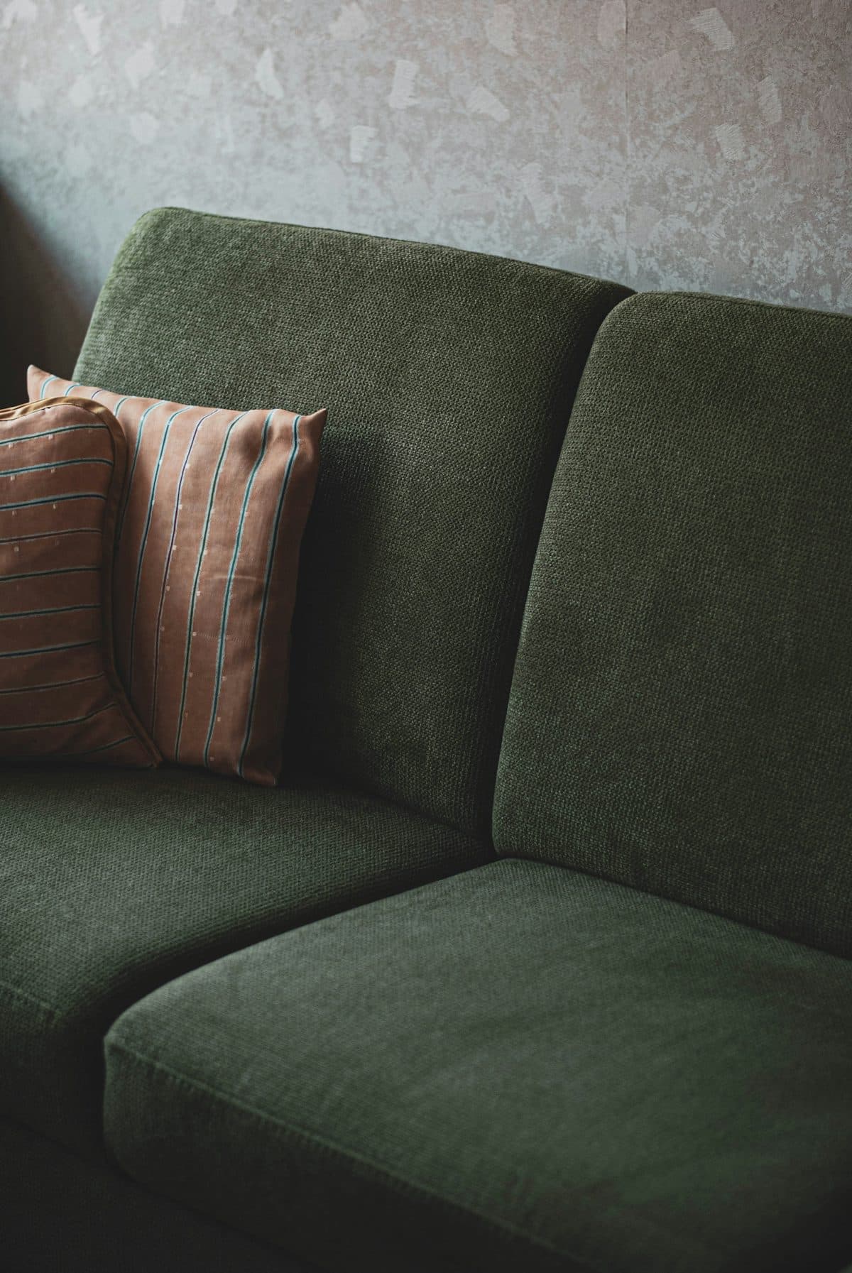 Green upholstered sofa illustrating pre-owned home furnishings